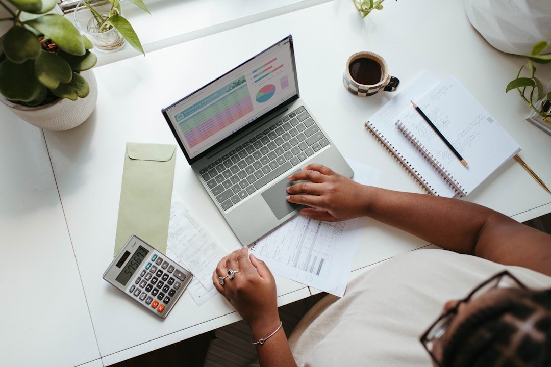 Abogado revisando presupuesto anual en laptop con gráficos financieros y documentos