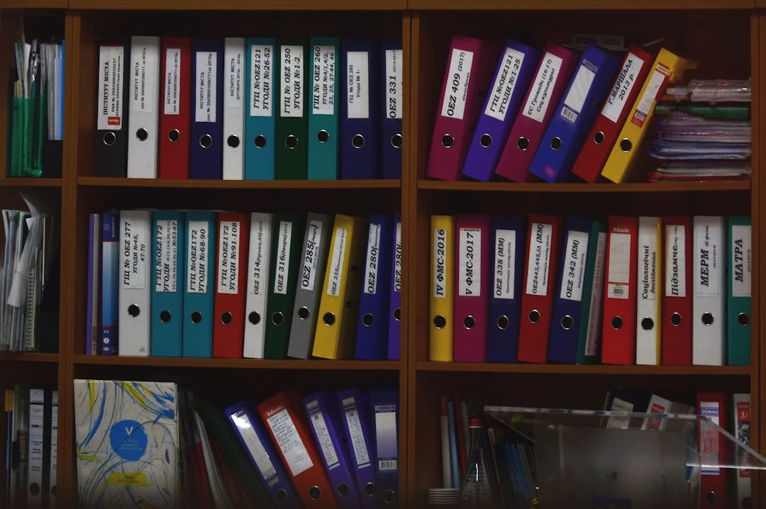 Abogado revisando documentos en computadora con expedientes organizados